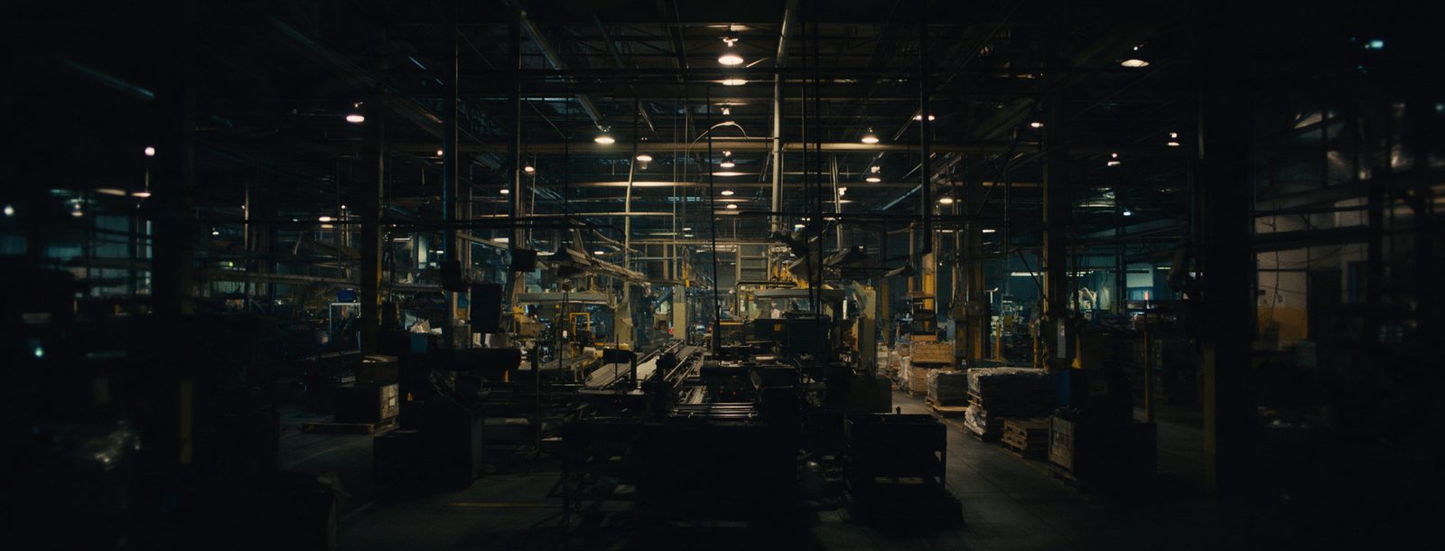 Nave de manufactura en operación, con maquinaria y luz de taller.